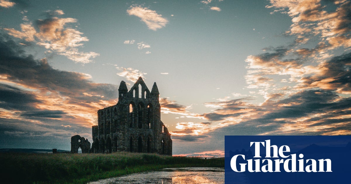 Whitby Abbey ruins with sunset and reflections.